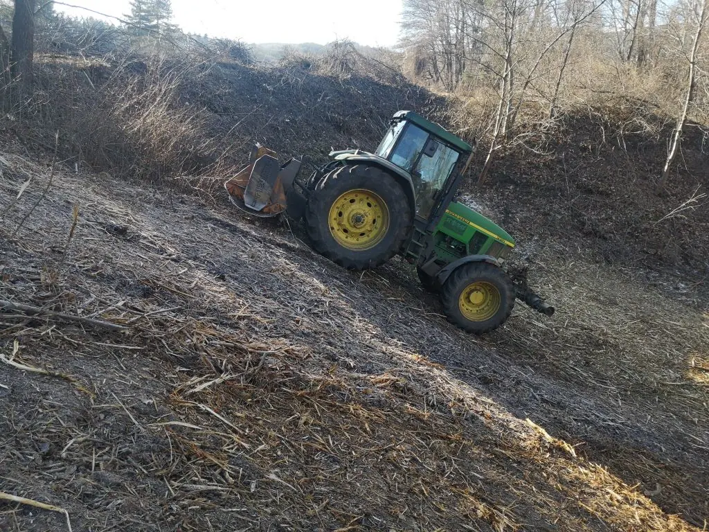 Maschine beim Arbeiten an einem schwierigen Hang neben einem Flussbett